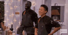 two chefs standing in front of a wall that says top chef on it