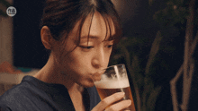 a woman drinking a glass of beer with a sticker that says ' taiwanese ' on it