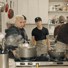 a group of men are cooking on a stove with z ky written on the bottom right