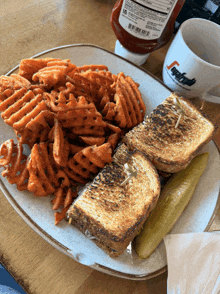 a sandwich and waffle fries on a plate with a cup that says segafredo