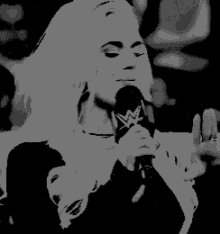 a woman is holding a microphone with a w logo on it