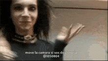 a woman in a black dress is holding a book in her hand and says `` move la camara si sos de victoria '' .