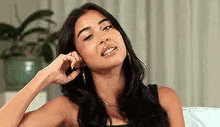 a woman is sitting on a couch with her hand in her hair .