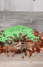 a pile of green and brown beads is on the floor .