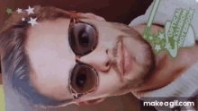 a man wearing sunglasses has a green sticker on his face that says optical illusion notebook