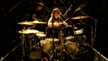 a man playing drums in front of a drum set that says tama on it