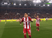 a soccer player in a red and white jersey with the number 50 on it