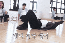 a man laying on the floor with a bottle of water in front of him