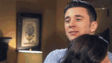 a man is hugging a woman in front of a picture