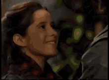 a young girl in a plaid shirt is smiling and looking at a man .