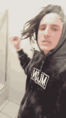 a man wearing a black hoodie with the word wow on the front