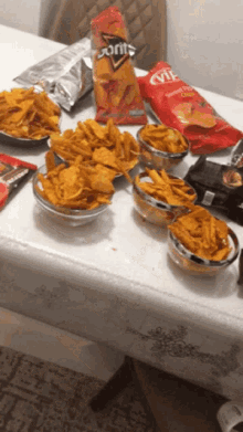 a bag of doritos sits on a table next to a bowl of chips