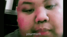 a close up of a man 's face with pink blush on his cheeks and the words `` your mom '' .