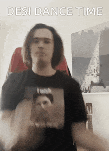 a man wearing a black shirt with a picture of a man and the words desi dance time above him