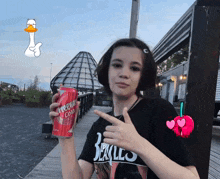 a girl wearing a black shirt that says berkles holds up a can of cherry cola