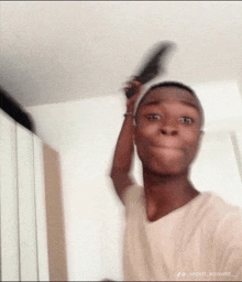 a man is brushing his hair with a comb and making a face .
