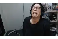 a man wearing headphones is making a funny face while sitting in front of a computer .