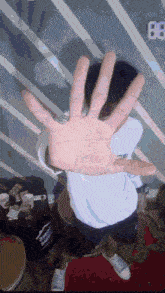 a person covering their face with their hand with the number 88 on the wall