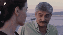 a man with a mustache is looking at a woman with the letter a on her head
