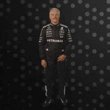 a man in a petronas suit giving the thumbs up
