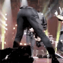 a man in a suit is dancing on a stage with a microphone .
