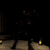 a black monster is standing in a dark room next to a lantern .