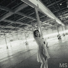 a woman in a white dress stands in an empty parking garage with the letters ms on the bottom