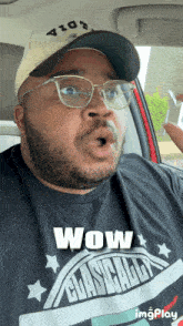 a man wearing glasses and a black shirt that says wow on it