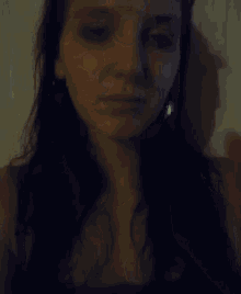 a woman with long dark hair is giving a thumbs up sign