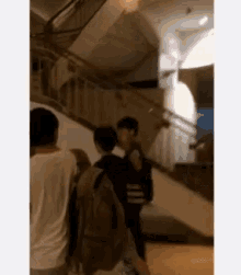a group of people are walking up a set of stairs .