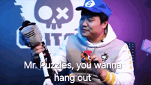 a man in a blue hat is holding a stuffed animal and says mr. puzzles you wanna hang out
