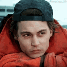a man wearing a baseball cap and a red jacket