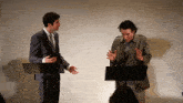 a man in a suit and tie is standing next to another man