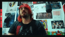 a man with red hair wearing a darth vader shirt stands in front of a microphone