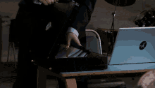 a man is opening a briefcase next to a laptop that says hp on it