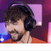 a man with a beard wearing headphones is smiling .
