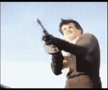 a man in a suit is pointing a gun in the air