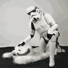a storm trooper is kneeling on a white blanket