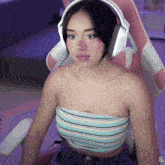 a woman wearing headphones sits in a pink chair with the letters xg on the bottom