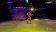 a female wrestler is dancing on a stage during a raw live event