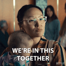 a woman holding a baby with the words " we 're in this together " below her