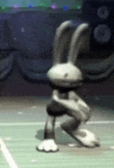 a cartoon rabbit is kneeling down on a green court .