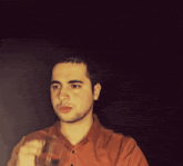 a man in a red shirt is holding a glass