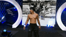 a man without a shirt is standing in front of a aew sign