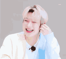a man with blonde hair is laughing with his mouth open