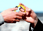 a man is holding a yellow watch in his hand