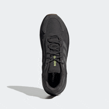 a pair of black adidas shoes with yellow stripes
