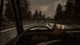 a person is driving down a road with a bunny hanging from the steering wheel