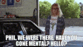 a man is standing in front of a car with the words `` phil we were there have you gone mental ? hello ? '' .
