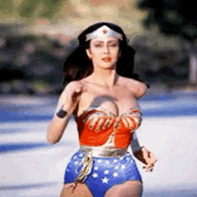 a woman in a wonder woman costume is running on a street .